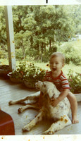 Kevin on Mamaw and Papaw Maddron's front porch, "riding" one of their dogs!