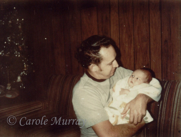 Billy holding brand new grandson, Chas, who was only 2 weeks old when this photo was taken.  (Christmas Day 1976)© Carolyn S. Murray 1976