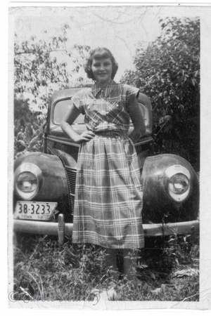 Amma at age 15, standing in front of a 1940 Ford.